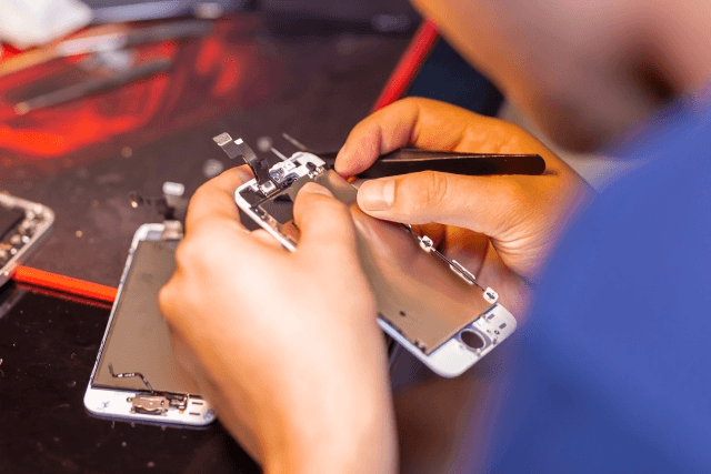 Repair technician working on a device in a workshop